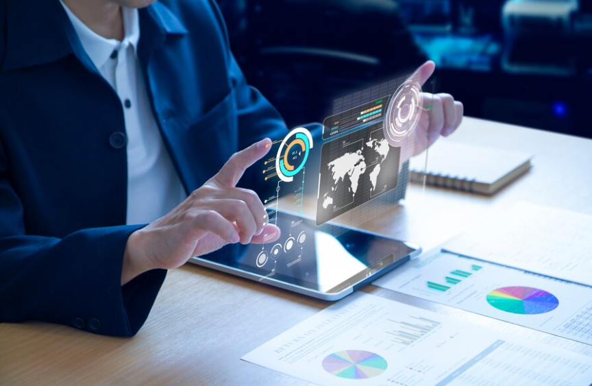 Analyst reviewing charts on a tablet beside printed reports